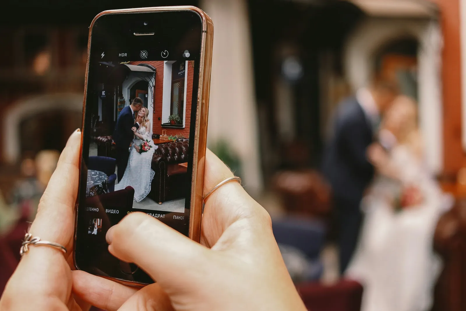 Invitada fotografiando a los novios con su celular